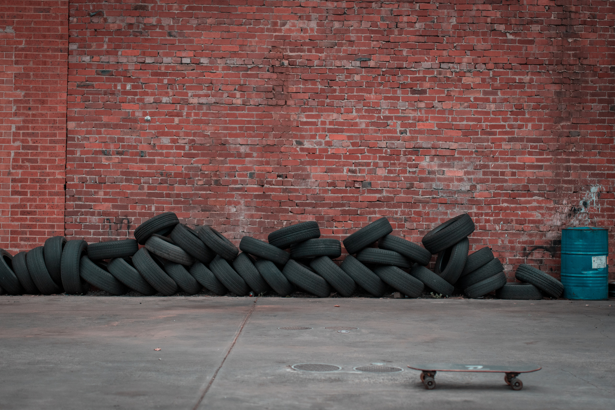 Black Car Tires Against Brown Brick Wall